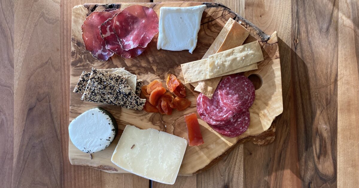 https://cooksandpoets.com/media/products/rustic-olive-wood-board/_1200x630_crop_center-center_none/Andrea_Brugi_olive_wood_cheese_board_2022-12-31-194643_iero.jpg